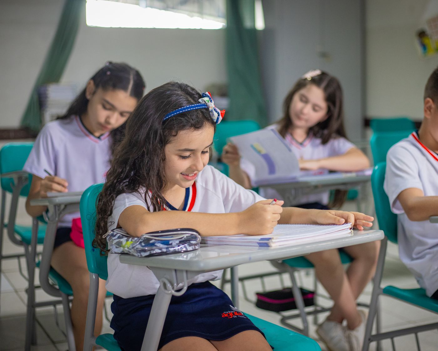 Aluna dos Anos Iniciais escrevendo em sala de aula