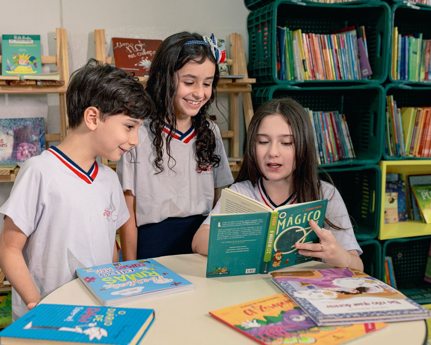 Alunos lendo juntos na biblioteca do colégio