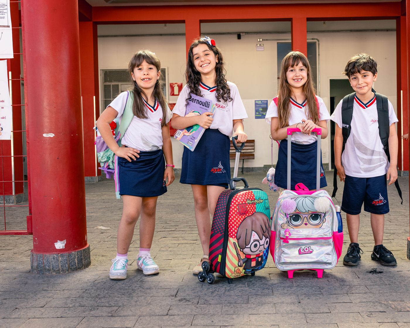 Alunos chegando à escola com suas mochilas